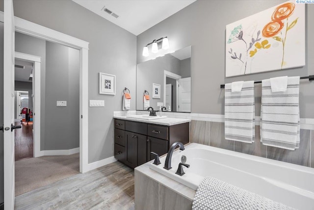 5298 S Quincy Pl, Kennewick, WA 99337 - bathroom featuring vanity, baseboards, visible vents, a bath, and wood finished floors