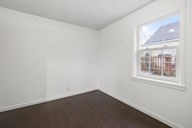 unfurnished room featuring dark hardwood / wood-style flooring and a textured ceiling