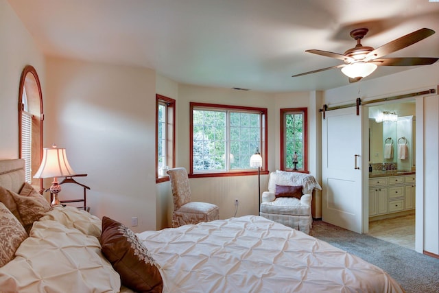 3114 Rd 103, Pasco, WA 99301 - carpeted bedroom with visible vents, ceiling fan, connected bathroom, and a barn door