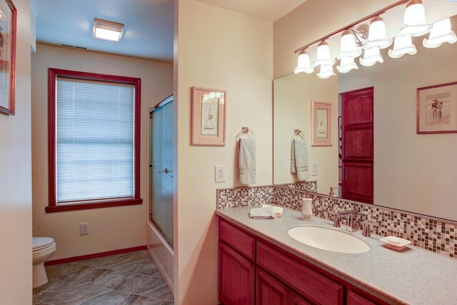 3114 Rd 103, Pasco, WA 99301 - full bath featuring shower / bath combination with glass door, tasteful backsplash, vanity, baseboards, and toilet