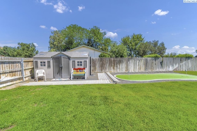 141 Travis Ln, Kennewick, WA 99338 - fenced backyard with a storage unit and a putting area