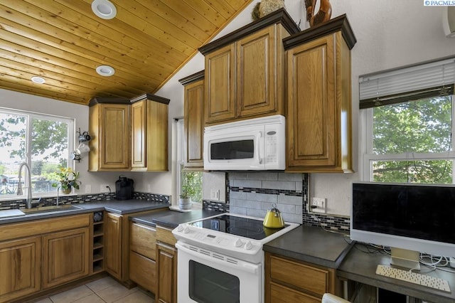 141 Travis Ln, Kennewick, WA 99338 - kitchen featuring white appliances, lofted ceiling, dark countertops, wood ceiling, and brown cabinetry