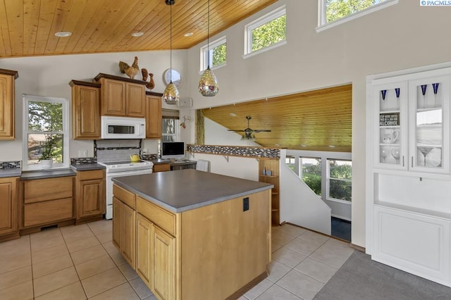 141 Travis Ln, Kennewick, WA 99338 - kitchen with white appliances, wood ceiling, light tile patterned floors, dark countertops, and healthy amount of natural light
