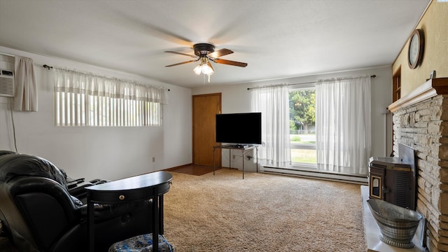 1707 W 19th Ave, Kennewick, WA 99337 - living room featuring a baseboard heating unit, a ceiling fan, a wood stove, and carpet