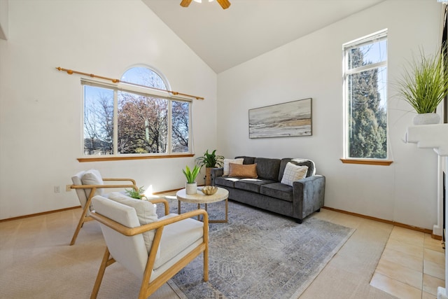 living room with high vaulted ceiling, a glass covered fireplace, a wealth of natural light, and a ceiling fan