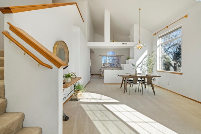 dining space featuring stairs, a wealth of natural light, and light colored carpet