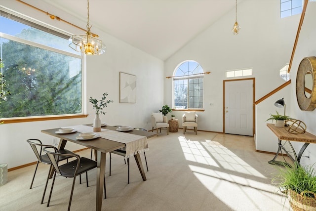 dining room featuring baseboards, high vaulted ceiling, an inviting chandelier, and light colored carpet