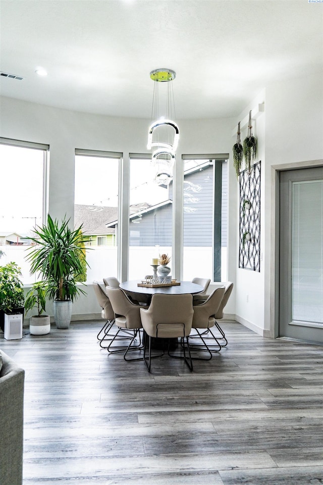 dining room with hardwood / wood-style floors and an inviting chandelier