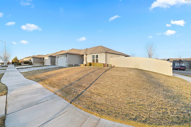 single story home featuring a garage and a front lawn