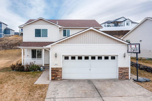 traditional-style house with an attached garage, covered porch, stone siding, and driveway