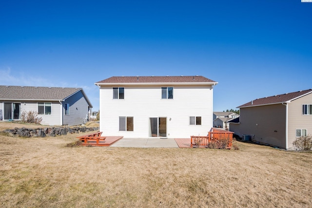 back of house featuring a yard, a wooden deck, and a patio area