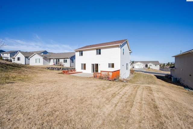 back of house with a residential view, central air condition unit, a yard, and a deck