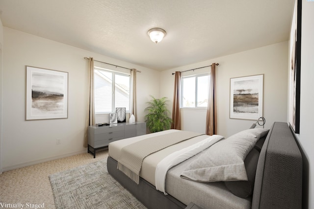 bedroom featuring light colored carpet and baseboards