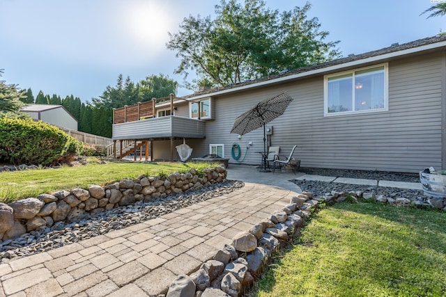 back of house with stairs, a patio, and a yard