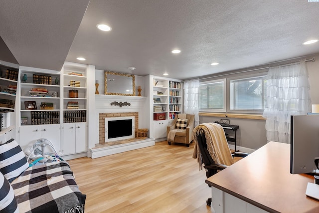 office space with a textured ceiling, a fireplace, wood finished floors, and recessed lighting