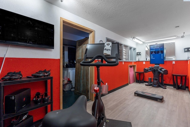 workout room with a textured ceiling and wood finished floors