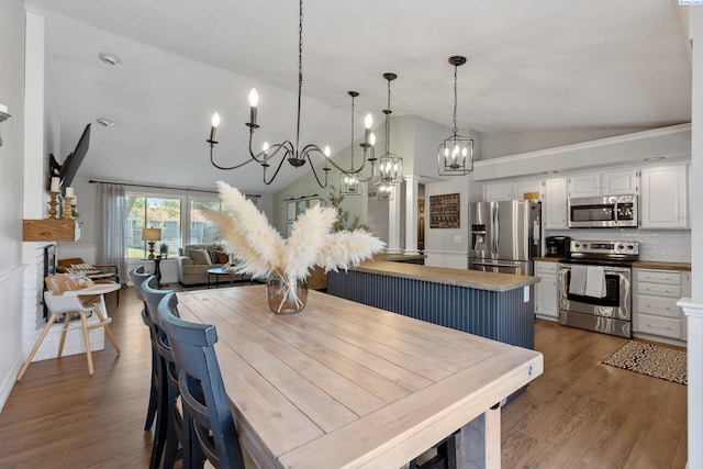 dining space with dark wood-style floors and vaulted ceiling