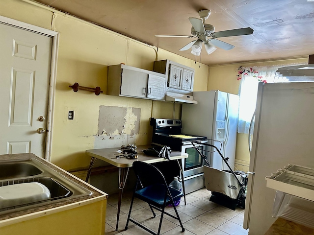 kitchen with stainless steel electric range oven, ceiling fan, freestanding refrigerator, under cabinet range hood, and light tile patterned flooring