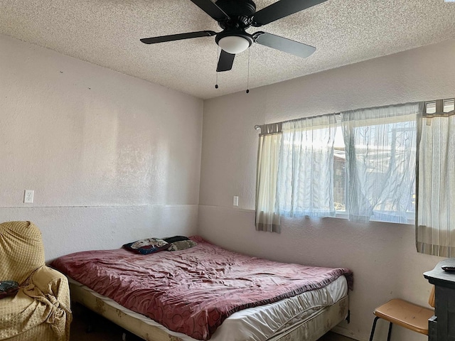 bedroom with a textured ceiling and a textured wall