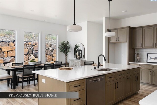 6653 W 27th Ave Unit 26, Kennewick, WA 99338 - kitchen with stainless steel dishwasher, a center island with sink, light wood finished floors, and light countertops