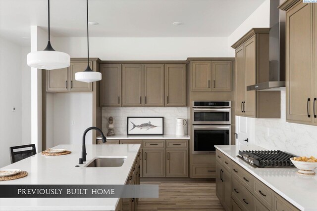 6653 W 27th Ave Unit 26, Kennewick, WA 99338 - kitchen with appliances with stainless steel finishes, wall chimney range hood, backsplash, pendant lighting, and wood finished floors