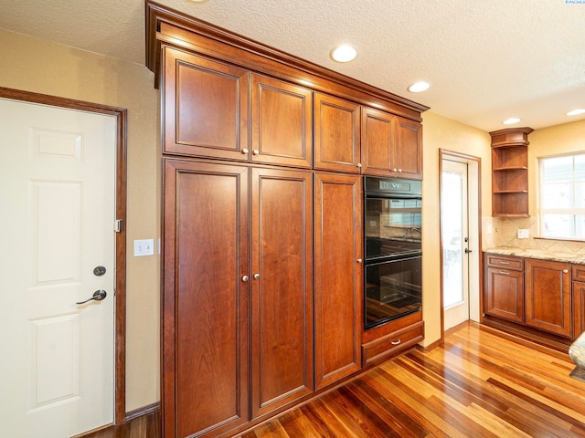 9203 Yakima Ct, Yakima, WA 98908 - kitchen featuring open shelves, dark wood-style flooring, a textured ceiling, backsplash, and brown cabinets
