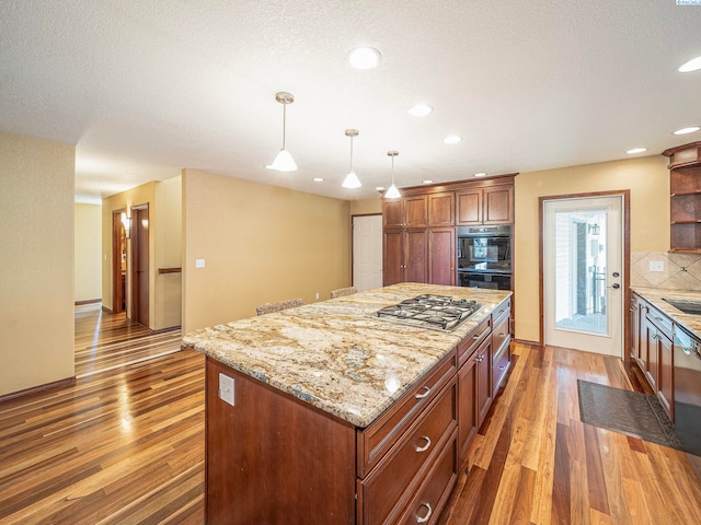 9203 Yakima Ct, Yakima, WA 98908 - kitchen with stainless steel gas cooktop, backsplash, light wood-type flooring, open shelves, and a center island