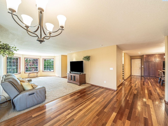9203 Yakima Ct, Yakima, WA 98908 - unfurnished living room with a textured ceiling, dark wood finished floors, a chandelier, and baseboards
