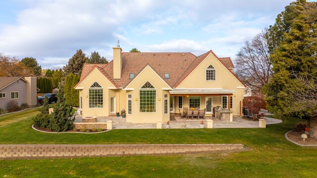 rear view of house with a patio area and a lawn