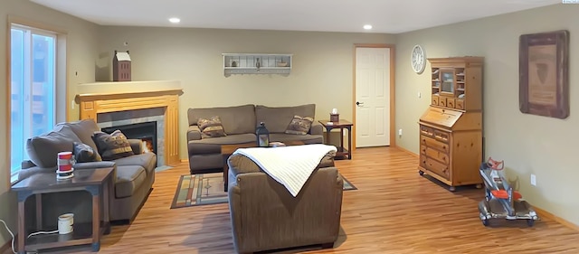 living room featuring light wood finished floors, a fireplace, and recessed lighting