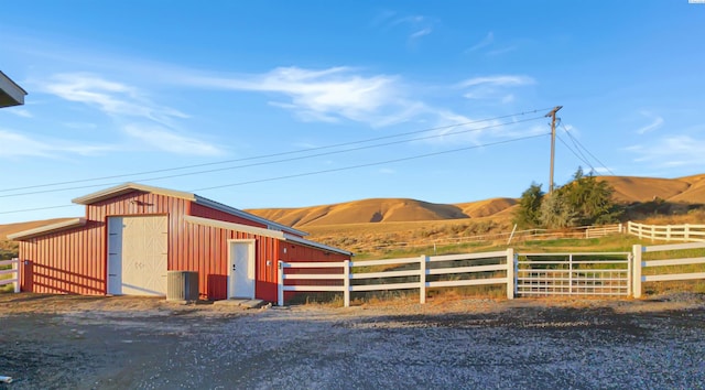 exterior space featuring fence, a mountain view, and an outdoor structure