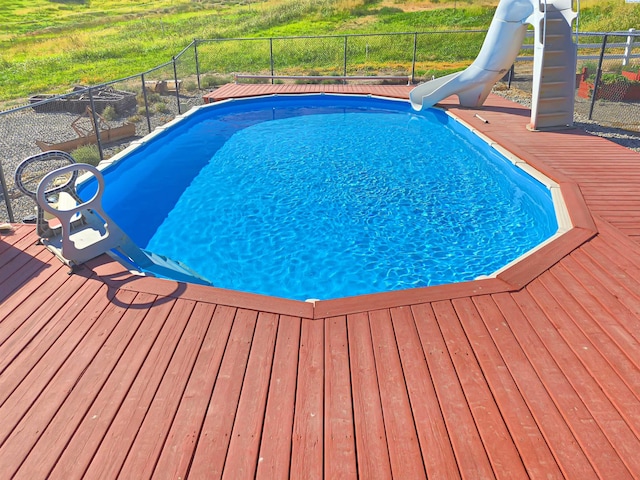 pool with a water slide and fence