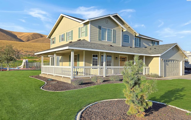 farmhouse with a porch, a mountain view, a garage, driveway, and a front lawn