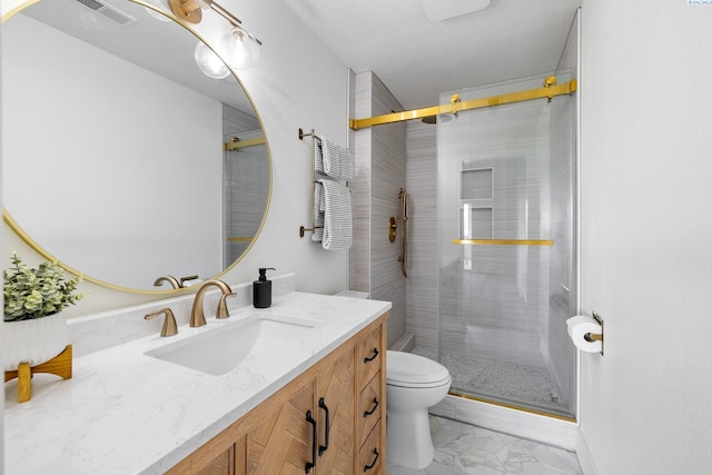 bathroom with vanity, a shower with door, and toilet