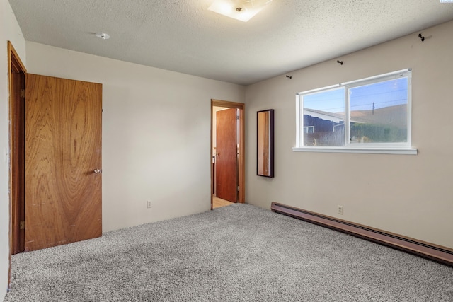 2001 Benson Ave, Prosser, WA 99350 - carpeted empty room featuring a baseboard radiator, a smoke detector, and a textured ceiling