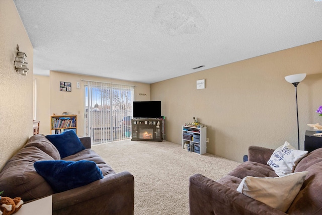 carpeted living room featuring a textured ceiling