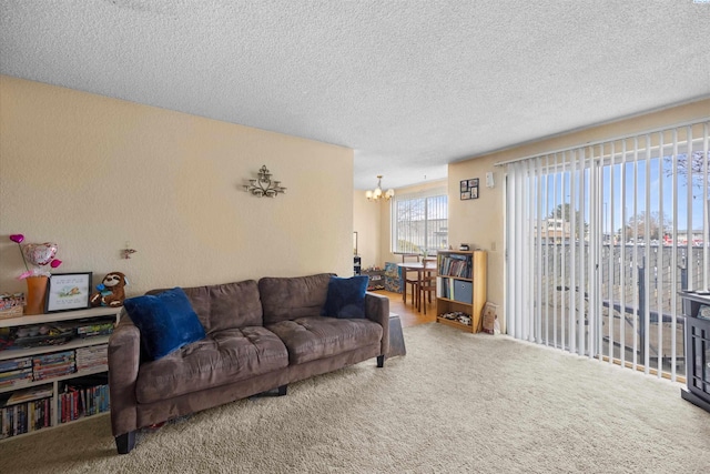 carpeted living room featuring an inviting chandelier and a textured ceiling