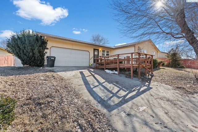 ranch-style house with a wooden deck and a garage