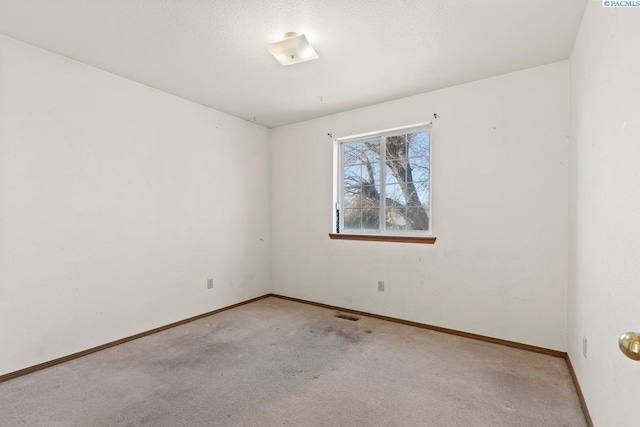 carpeted empty room featuring a textured ceiling