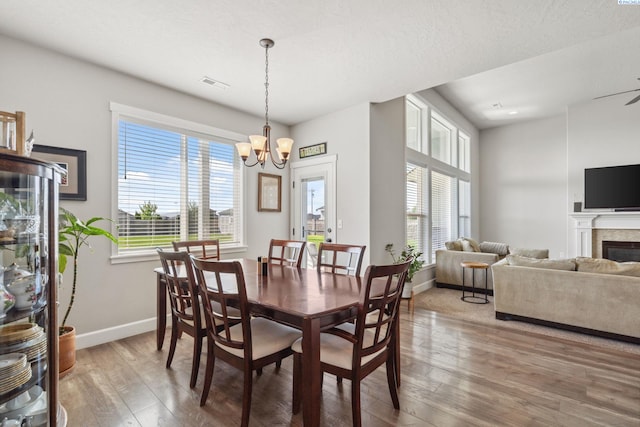 6624 Recurve Rd, Pasco, WA 99301 - dining area with wood-type flooring, a chandelier, baseboards, and a glass covered fireplace