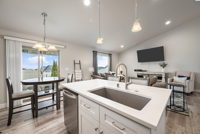 kitchen with a center island with sink, open floor plan, a sink, and stainless steel dishwasher