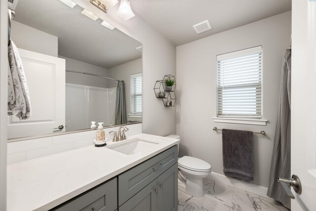 full bath with baseboards, visible vents, toilet, marble finish floor, and vanity