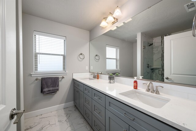 full bathroom with marble finish floor, visible vents, baseboards, and a sink