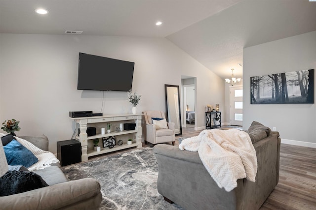 living room with baseboards, visible vents, wood finished floors, vaulted ceiling, and a notable chandelier