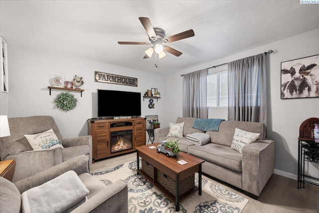 736 E 5th Ave, Kennewick, WA 99336 - living room with light wood-type flooring, a ceiling fan, and a glass covered fireplace