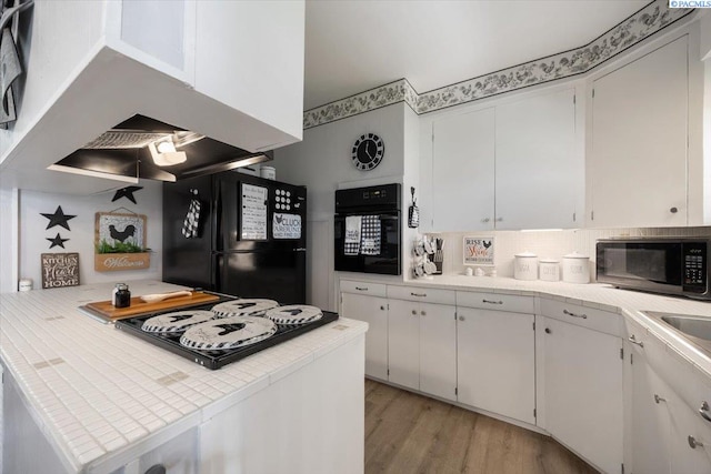 736 E 5th Ave, Kennewick, WA 99336 - kitchen with black appliances, white cabinetry, and light wood finished floors