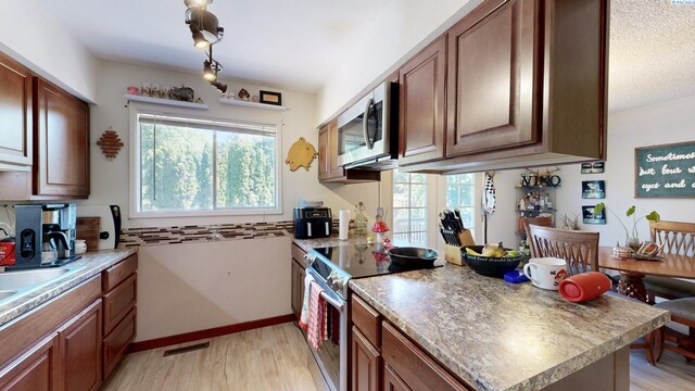 220 E Cannon, Palouse, WA 99161 - kitchen featuring appliances with stainless steel finishes, light wood-style flooring, and brown cabinets