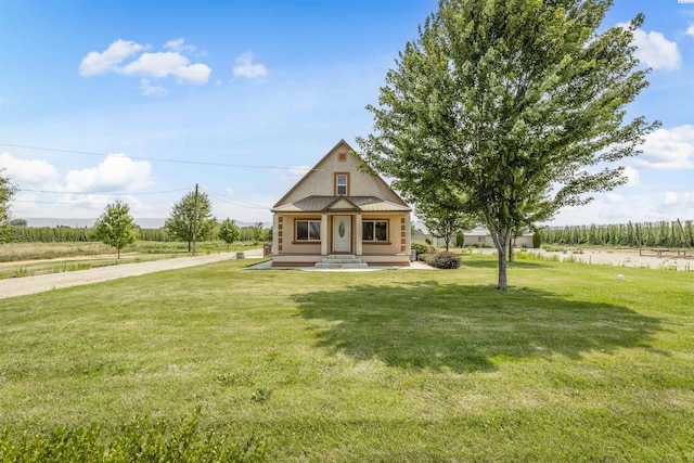 view of front of house featuring a front lawn and a rural view