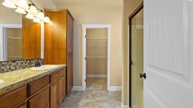1867 S Fescue St, Kennewick, WA 99338 - full bathroom with double vanity, a spacious closet, and decorative backsplash