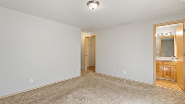 5704 Taft Dr, Pasco, WA 99301 - unfurnished bedroom featuring light colored carpet, a spacious closet, connected bathroom, and a closet